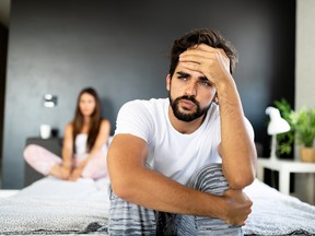 Unhappy couple having sexual problems in bed.