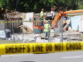 Workers remove belongings from the home where a sinkhole swallowed Jeffrey Bush on March 4, 2013 in Seffner, Florida.
