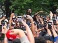 People gather around and cheer for Kai Cenat (C) as members of the NYPD respond to thousands of people gathered for a "giveaway" event announced by popular Twitch live streamer Kai Cenat in Union Square and the surrounding area on August 4, 2023 in New York City. Cenat, who announced on social media that he would be giving away video game consoles and other items, is reportedly in police custody after a crowd sparked disorder in the park leading to numerous arrests.