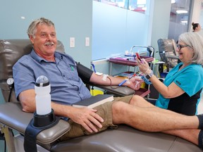 Steve Thor donates blood with phlebotomist Debbie Prasad at Canadian Blood Services in Calgary on Monday, August 28, 2023. Thor was making his 121st donation having started donating when he was 17 years old. Canadian Blood Services is urging everyone who can to donate blood or plasma to help boost supplies. Gavin Young/Postmedia