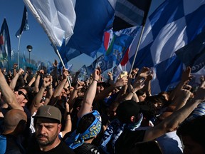 Fans of SSC Napoli gather on May 5, 2023 outside the club's training centre in Castel Volturno, north of Naples, hoping to welcome Napoli's players whose plane landed at the nearby military airport of Caserta - Grazzanise.