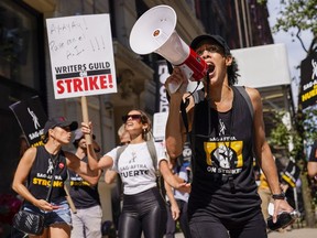 A strike captain, right, leads the chants as strikers walk a picket line outside Warner Bros., Discovery, and Netflix offices in Manhattan, Friday, Aug. 18, 2023.