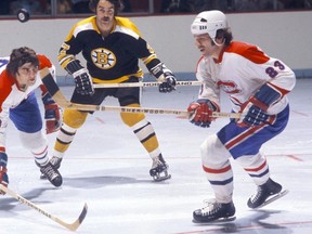 Canadiens' Bob Murdoch, right, with Bruins forward Derek Sanderson (centre) and Canadiens' Serge Savard (left) during an early 1970s game at the Montreal Forum.