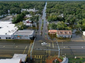 In an aerial view, a vehicle drives through a flooded street in the downtown area after Hurricane Idalia passed offshore on Aug. 30, 2023 in Crystal River, Fla.