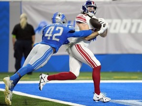 New York Giants tight end Tommy Sweeney, defended by Detroit Lions linebacker Jalen Reeves-Maybin (42), catches a 14-yard pass for a touchdown during the first half of an NFL preseason football game, Friday, Aug. 11, 2023, in Detroit.