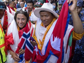 Norwegian climber Kristin Harila, left, and her Nepali sherpa guide Tenjen Sherpa, right, who climbed the world's 14 tallest mountains in record time, arrive in Kathmandu, Nepal, Saturday, Aug. 5, 2023.