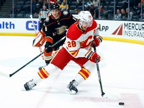 Calgary Flames forward Elias Lindholm skates with the puck against Anaheim Ducks forward Ryan Strome at Honda Center in Anaheim on Tuesday, March 21, 2023.