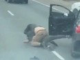 Screenshot from video of two men wrestling on Hwy. 401 near Leslie St. in a road-rage incident.