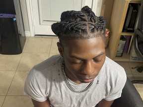 In this photo provided by Darresha George, her son Darryl George, 17, a junior at Barbers Hill High School in Mont Belvieu, Texas, sits for a photo showing his locs, at the family's home, Sept. 10, 2023. The same week a state law went into effect prohibiting discrimination on the basis of hair, George was suspended because his locs did not comply with the district's dress code.