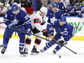 Maple Leafs forward Pontus Holmberg (left) and defenceman John Klingberg (right) try to squeeze out Ottawa Senators' Drake Batherson as they chase down a puck during pre-season action in Toronto on Monday, Sept. 25, 2023.