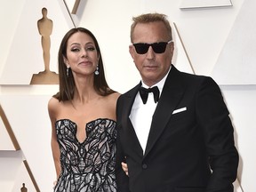 Christine Baumgartner and Kevin Costner arrive at the Oscars, March 27, 2022, at the Dolby Theatre in Los Angeles.