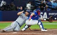 Texas Rangers' Corey Seager (left) scores ahead of the tag from Blue Jays catcher Tyler Heineman at Rogers Centre last night. The Jays lost 6-3. Nathan Dennette/The Canadian Press