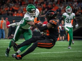 Saskatchewan Roughriders linebacker Derrick Moncrief (42) tackles BC Lions wide receiver Dominique Rhymes (19) as he completes a pass during second half of CFL football action in Vancouver on Friday.
