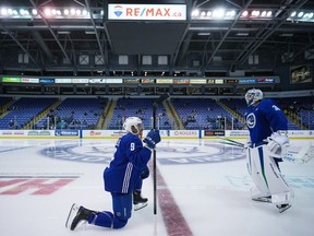 Vancouver Canucks' J.T. Miller talks with goalie Spencer Martin before an on-ice session during the opening day of the NHL hockey team's training camp, in Victoria, Thursday, Sept. 21, 2023.