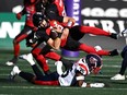 Redblacks quarterback Dustin Crum is tackled by the Alouettes' Reggie Stubblefield ni the first half.