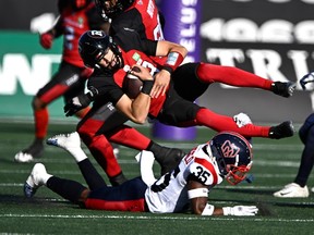 Redblacks quarterback Dustin Crum is tackled by the Alouettes' Reggie Stubblefield ni the first half.