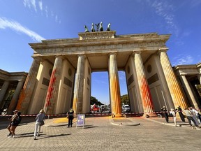 Members of the climate protection group Last Generation have sprayed the Brandenburg Gate with orange paint in Berlin, Germany, Sunday, Sept. 17, 2023.
