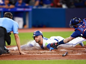 Blue Jays’ Kevin Kiermaier is tagged out at home plate by Rangers’ Jonah Heim at the Rogers Centre Monday night.