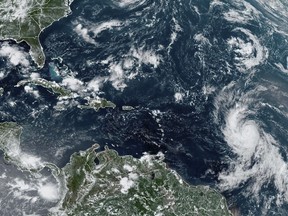 This Wednesday, Sept. 6, 2023, satellite image provided by the National Oceanic and Atmospheric Administration shows Hurricane Lee, right, off in the central tropical Atlantic Ocean.