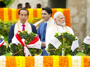 Prime Minister Justin Trudeau walks past Indian Prime Minister Narendra Modi, right, and President of Indonesia Joko Widodo as they take part in a wreath laying ceremony at Raj Ghat (Mahatma Gandhi's cremation site) during the G20 Summit in New Delhi, India on Sunday, Sept. 10, 2023.