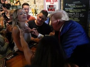 Screenshot of Donald Trump signing womans tank top at bar in Iowa.