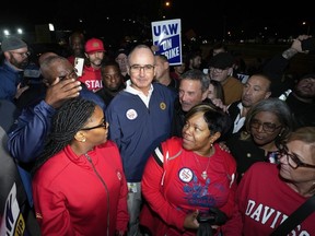 United Auto Workers President Shawn Fain stands with UAW members striking at Ford's Michigan Assembly Plant in Wayne, Mich., early Friday, Sept. 15, 2023.
