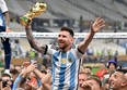 Lionel Messi of Argentina celebrates with teammates and the FIFA World Cup.