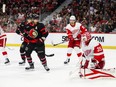 Ville Husso of the Detroit Red Wings makes a pad save as Claude Giroux of the Ottawa Senators looks on.