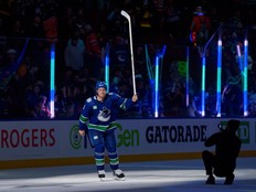 Gino Odjick stands alongside Brock Boeser, Elias Pettersson, and