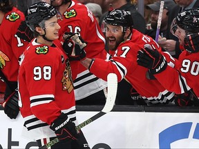 Connor Bedard #98 of the Chicago Blackhawks celebrates with Nick Foligno #17 and Tyler Johnson #90 after scoring his first NHL goal during the first period of the Boston Bruins home opener at TD Garden on October 11, 2023 in Boston.