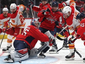 Washington Capitals goaltender Darcy Kuemper makes a save as Calgary Flames players crash the net at Capital One Arena in Washington on Monday, Oct. 16, 2023.