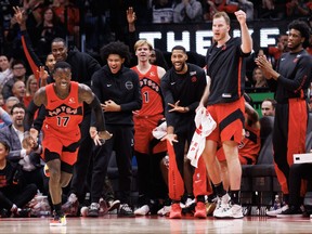 The Toronto Raptors bench celebrates behind teammate Dennis Schroder, left, after Schroder made a basket against the Minnesota Timberwolves during the first half of their NBA game at Scotiabank Arena on Wednesday, Oct. 25, 2023, in Toronto.