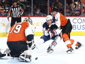 Mattias Janmark #13 of the Edmonton Oilers and Travis Sanheim #6 of the Philadelphia Flyers challenge for the puck during the first period at the Wells Fargo Center on October 19, 2023 in Philadelphia, Pennsylvania.