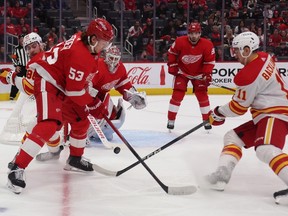 Calgary Flames forwards Mikael Backlund and Andrew Mangiapane battle Detroit Red Wings defenceman Moritz Seider at Little Caesars Arena in Detroit on Sunday, Oct. 22, 2023.