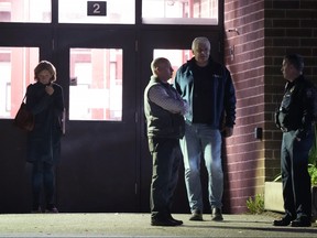 People stand outside a reunification center early Thursday, Oct. 26, 2023, at Auburn Middle School in Auburn, Maine after shootings Wednesday at a bar and a bowling alley in Lewiston, Maine.