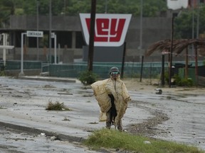 A Mexican soldier guards near an avenue flooded by the rains of Hurricane Norma in San Jose del Cabo, Mexico, Saturday, Oct. 21, 2023.
