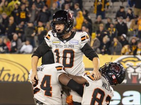 B.C. Lions kicker Sean Whyte, centre is hoisted by teammates Patrice Rene, left, and Terry Williams after kicking a game-winning field goal to defeat the Hamilton Tiger-Cats in CFL football game action in Hamilton, Ont. on Friday, Oct. 13, 2023.