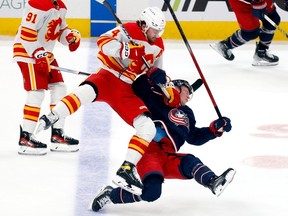 Calgary Flames defenceman Rasmus Andersson checks Columbus Blue Jackets forward Patrik Laine at Nationwide Arena in Columbus, Ohio, on Friday, Oct. 20, 2023.