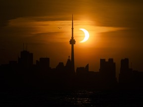 The sun rises behind the skyline during an annular eclipse on June 10, 2021 in Toronto.