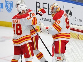 Calgary Flames defenseman Dennis Gilbert (48) and goaltender Dan Vladar (80) celebrate after a victory in an NHL hockey game against the Buffalo Sabres, Thursday, Oct. 19, 2023, in Buffalo, N.Y.