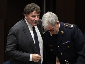 Public Safety Minister Dominic LeBlanc speaks with RCMP deputy commissioner Mark Flynn as they prepare to appear at the Senate national security, defence and veterans affairs committee in Ottawa on Monday, Oct. 23, 2023.