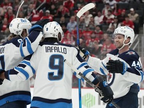 Winnipeg Jets defenceman Josh Morrissey (44) celebrates a goal by left wing Kyle Connor, left, during the first period of an NHL hockey game against the Detroit Red Wings, Thursday, Oct. 26, 2023, in Detroit.