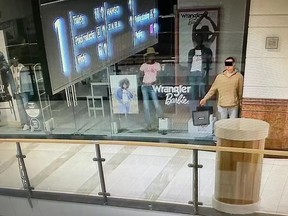 Man in Warsaw clothes shop pretending to be a mannequin in store window.