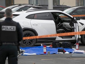 Police investigate the vehicle where Gregory Woolley was shot in a shopping centre in St-Jean-sur-Richelieu on Friday Nov. 17, 2023.