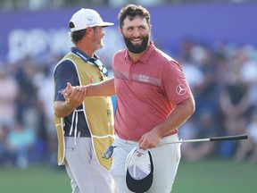 Jon Rahm of Spain shakes hands with his caddie, Adam Hayes (obscured) on the 18th green during Day Four of the DP World Tour Championship.