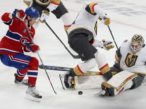 Montreal Canadiens' Juraj Slafkovsky (20) gets in close to Vegas Golden Knights goaltender Adin Hill as a loose puck falls between his legs with Vegas Golden Knights' William Karlsson (71) falling into the play, during second period NHL action in Montreal on Thursday Nov. 16, 2023.
