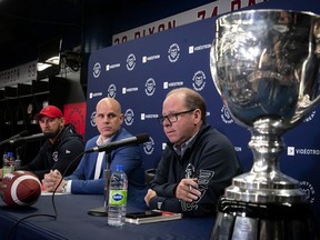 With the Grey Cup in the foreground, Alouettes GM Danny Maciocia, right, speaks to reporters with head coach Jason Maas, left, and president Mark Weightman, centre, on Wednesday at Olympic Stadium.