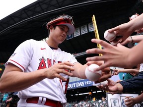 Shohei Ohtani of the Los Angeles Angels signs autographs during Gatorade All-Star Workout Day at T-Mobile Park on Monday, July 10, 2023, in Seattle.