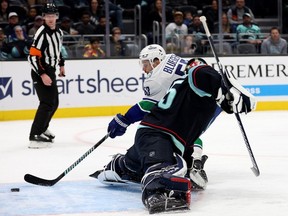 Teddy Blueger of the Vancouver Canucks scores against Joey Daccord of the Seattle Kraken during the first period at Climate Pledge Arena on November 24, 2023 in Seattle.
