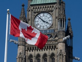 A Canadian flag flies in front of the Peace Tower on Parliament Hill in Ottawa.